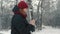 Funny and cute woman in a red warm hat on her head writes a quick message about important matters using a smartphone in