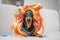 Funny dachshund wearing golden blond wig with hair bands and curlers.