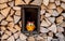 Funny decoration owl standing in the middle of a wood stack