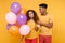 Funny dissatisfied friends couple african american guy girl in casual clothes isolated on yellow background. Birthday