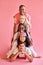 Funny diverse people in a row isolated over pink background