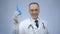 Funny doctor holding rectal syringe with smile on face, proctologist joking