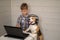 Funny dog Beagle in headphones with a microphone stands on his hind legs next to the boy