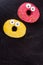 Funny donuts on black background, top view.