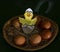 A funny drawn chick hatches out of the egg in a basket of real eggs in the straw