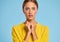 Funny emotional girl in a yellow sweater with a surprised scared face on    blue background