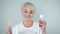 Funny emotional senior woman holding toothbrush and bottle with mouthwash