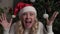 Funny emotional woman shouts with joy on the background of the Christmas interior