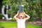 Funny excited child waters plants in backyard garden with watering can.