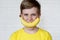 Funny face with banana smile. Angry boy. Young boy in yellow t-shirt holding banana with a smile