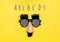 Funny face - fake eyeglasses, nose and mustache, confetti, sequins on yellow background Happy fools day concept 1st April party