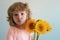 Funny face of son child with bouquet of sunflower flowers. Spring family holiday concept. Womens day. Children