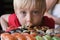 Funny fair-haired boy stares at Sushi. Child boy in cafe concept. Asian cuisine