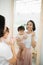 Funny family at home. Mother and her child girl are doing your makeup and having fun near mirror. Baby girl explores mother`s