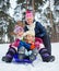 Funny family is sledging in winter-landscape