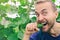 Funny farmer eating fresh harvested cucumber inside greenhouse. Smiling gardener near vegetable bed. Organic gardening, local bio