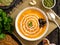 Funny food for Halloween. Pumpkin puree soup, spider web, dark old wooden table, top view.