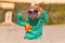 Funny French Bulldog dog dressed up with cactus costume with fake arms and orange fowers wearing summers traw hat and sunglasses