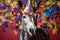 Funny and friendly cute donkey or mule wearing a brithday party hat in studio, on a vibrant, colorful background. Generative AI