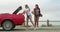 Funny friends open boot with skateboard at beach, smile and walking outdoor. Happy women on car trunk for skating