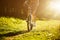 Funny girl driving bicycle outdoor. Sunny summer lifestyle concept. Woman in dress and hat in Field with dandelions