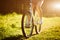 Funny girl driving outdoor. Focus on bicycle. Sunny summer lifestyle concept. Woman in dress and hat in Field with