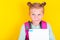 Funny girl from elementary school with book and backpack on yellow background. School concept,education. Back to School.