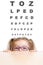 Funny girl in eyeglasses with eye chart