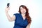 Funny girl grimaces and makes selfie on smartphone