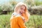 Funny girl hold rabbit on green field background. Closeup of winking girl with bunny rabbit. Lovely woman hold white