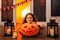 A funny girl looks with surprise at a spider on an orange pumpkin