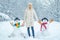 Funny Girl Love winter. Winter portrait of young woman in the winter snowy scenery. Cute girl making snowman on snowy