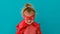 Funny girl in red superhero costume with mask waves hand