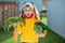 Funny girl with two pigtails in yellow smiling with fresh autumn harvest in sunny rural garden