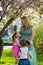 Funny girls walking on the lawn with her mother. Sisters play together with mom. maternal care. happy family