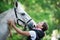 Funny gray horse reaching for kiss from girl-coach