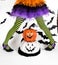 Funny green black Striped legs of a little girl with halloween costume of a witch with witch shoes and smiley halloween pumpkin