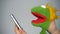 Funny green puppet browsing in smartphone