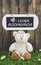 Funny greeting card with teddy bear and a wooden white sign with