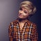 Funny grimacing woman with short blond hair style posing in yell