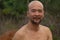 Funny grinding Japanese beard bald man portrait topless in nature background
