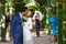 Funny groom kissing bride in wedding dress under the arch