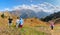 Funny group of people hiking on the meadow of mountain