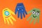Funny hand shaped monsters on orange background, flat lay. Halloween decoration