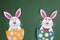 Funny handmade cartoon rabbits placed inside eggs with copyspace