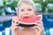 Funny handsome boy eating slice water melon