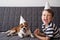 Funny happy chihuahua dog with preschool boy. Birthday dog in party hat.