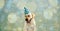 FUNNY AND HAPPY DOG CELEBRATING A BIRTHDAY OR NEW YEAR WITH A GREEN AND WHITE POLKA DOT PARTY HAT AND SMILING WITH CLOSED EYES.