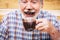 Funny happy senior people caucasian old man drinking hot chocolate and have it on nose and beard - laugh and have fun - concept of