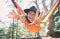 Funny happy woman tourist in felt hat swings on hammock in pine forest and tries to reach camera with her hands. Cheerful smiling